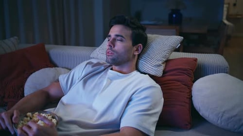 Man Relaxes on Couch Watching Television