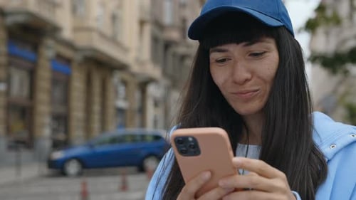 Happy Woman Enjoying Success While Looking at Mobile Phone with City Sun Background Closeup of