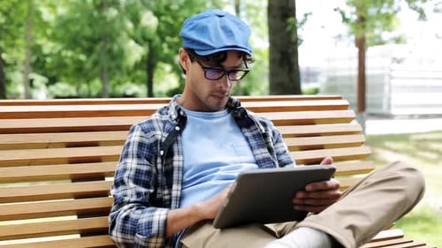 Creative hispanic man browsing on tablet by fixed gear bicycle in city summer