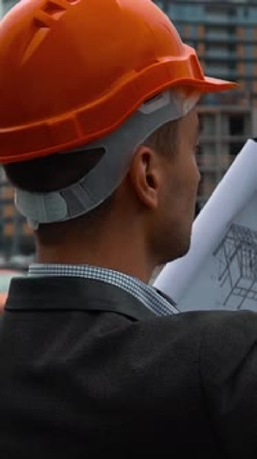 Architect Examines Blueprint and Takes Photo