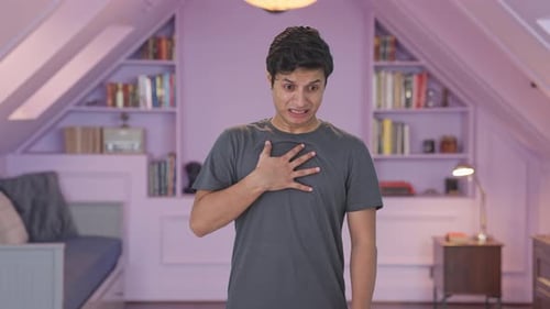 Man Clutching Chest in Discomfort Indoors