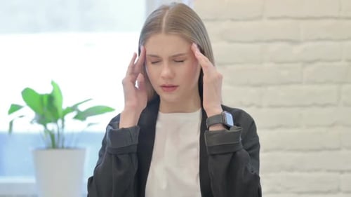 Young Woman Rubbing Temples Experiencing a Headache