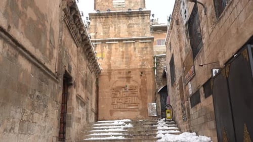 The camera, positioned on the stairs leading down from the minaret of the Mardin Ulu Mosque, reveals
