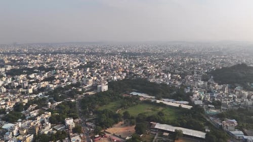 Drone footage capturing Hyderabad during December, featuring a misty skyline, tightly packed