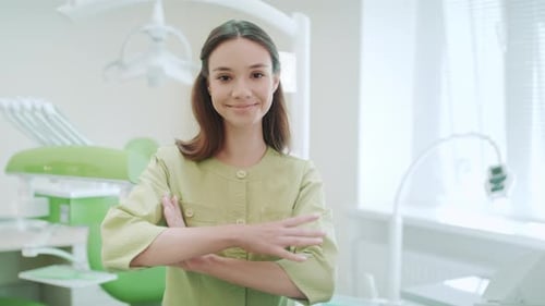 Smiling Dentist in Dental Clinic Interior. Portrait of Woman Dentist with Hands