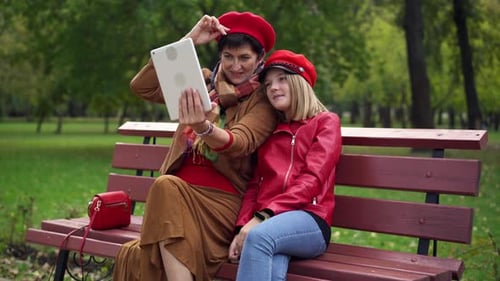 Woman and Teen Enjoying Tablet in Park