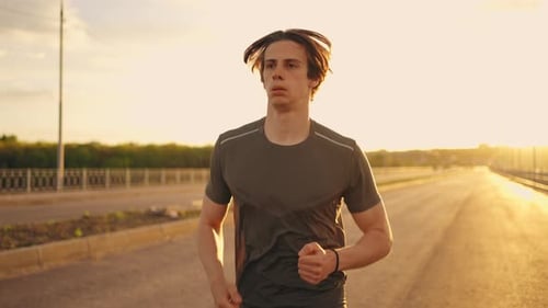 Medium Portrait of Running Man in Sunny Morning Athlete is Jogging on Empty Road Training Alone