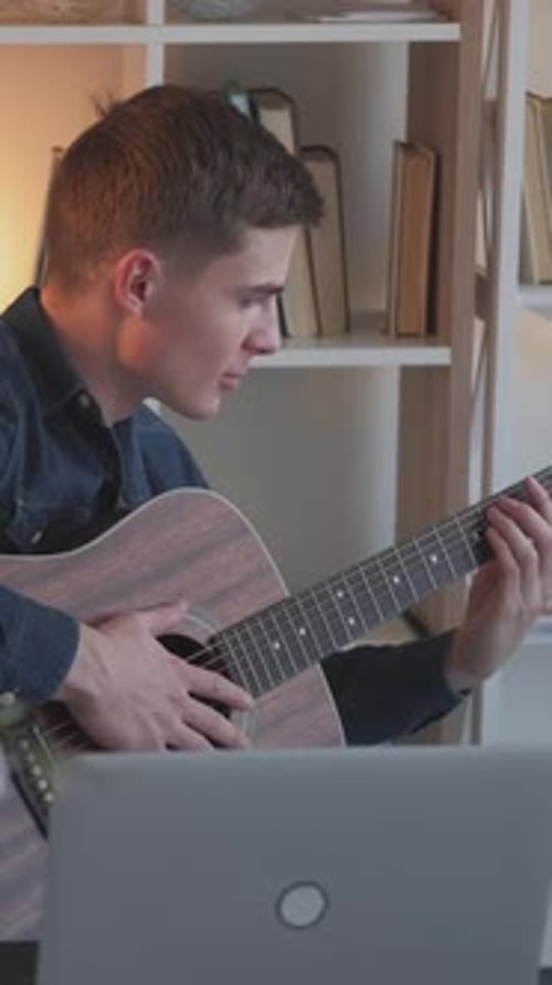 Young Man Plays Acoustic Guitar at Home