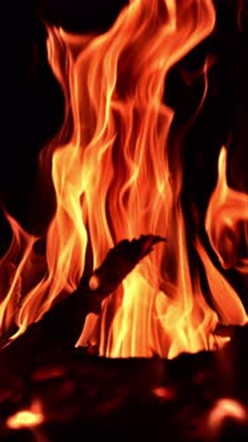 Night fireplace glowing. Bonfire flame heating in slow motion.