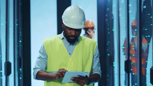 A Construction Worker Effectively Using a Tablet in a Modern and Advanced Facility Environment