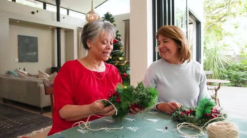 Women Crafting Christmas Wreaths in Cozy Home