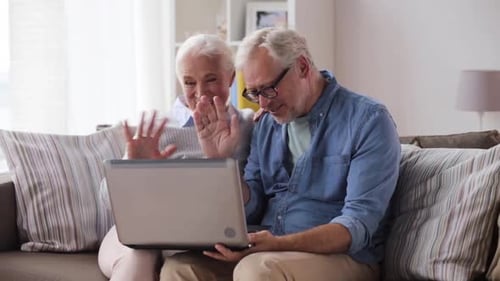 Happy Senior Couple Video Calling on Laptop at Home