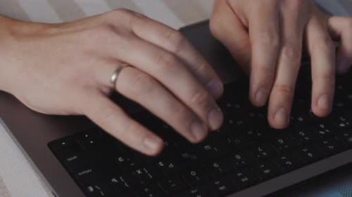 Male Hands Typing on Laptop Keyboard Close Up with Relaxed Fingers