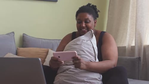 Woman on Couch Using Smartphone at Home