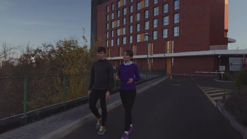 Athletic Couple Walk and Chat in an Urban Setting