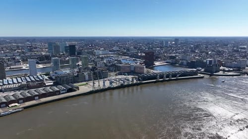 Pan left aerial view of Antwerp skyline and Scheldt river