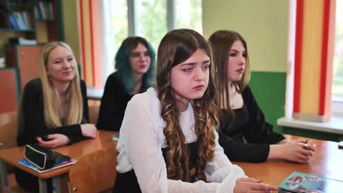 Focused High School Female Students Engaged in Classroom Lesson with Teacher