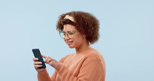 Phone, news and happy woman in studio for social media, text or chat on blue background