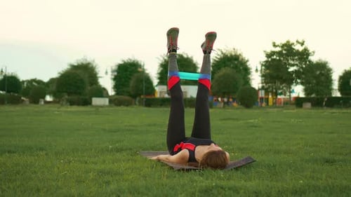 Woman Exercising with Resistance Band in Park