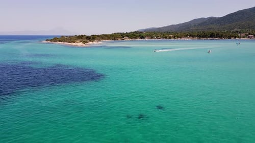 Aerial View of a Lone Boat Speeding Across the Calm Dark Blue Ocean Leaving a Trail of White Waves