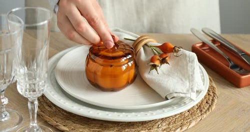 Pumpkin Candle Lit on Festive Thanksgiving Table Setting