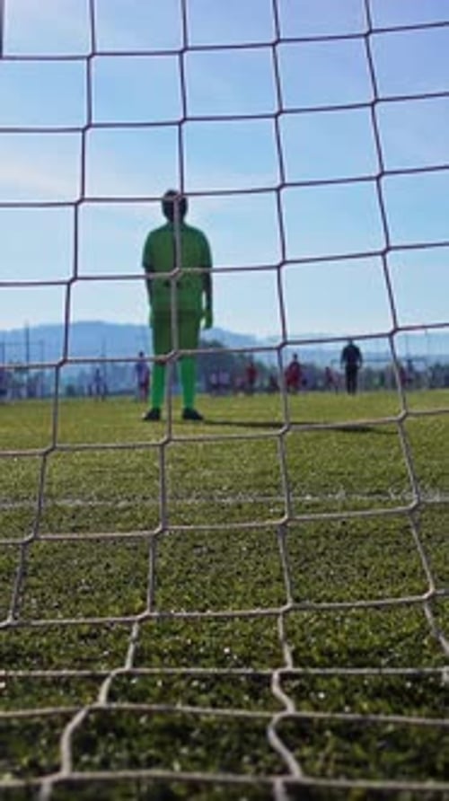 Soccer Goalie Standing on Field Through Goal Net