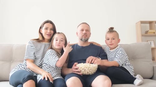 Family Watching a Movie Together on Sofa at Home