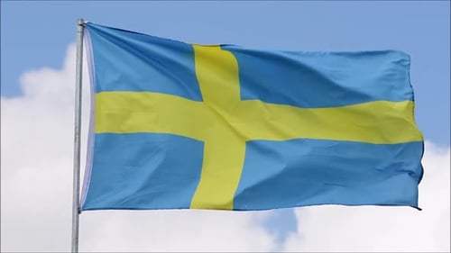 Swedish Flag Waving Proudly Against a Cloudy Blue Sky