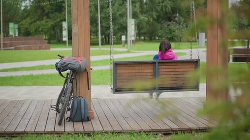 Woman Swings Peacefully Calm Moment As Woman Swings Amid Tranquil Park Surroundings Peaceful Scene