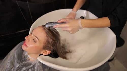 Woman having hair rinsed at hair salon