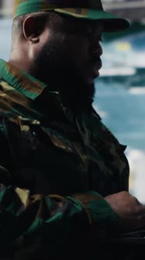 Man in Camouflage Uniform Using Electronic Device