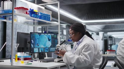 Especialista negra analisando amostras em laboratório de química com microscópio