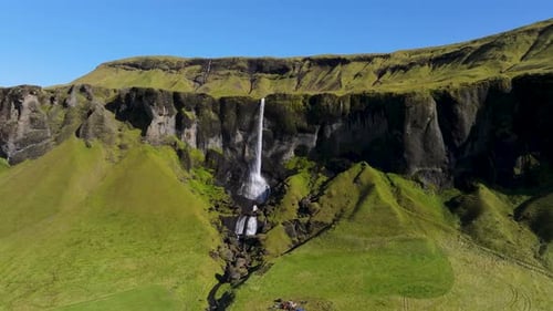 Aerial view of waterfall cascading down cliff, Iceland.
