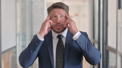 Portrait of Middle Aged Businessman with Headache in Office