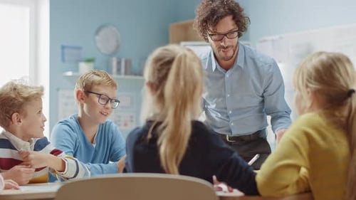 Teacher Explains Lesson to Young Students in Classroom