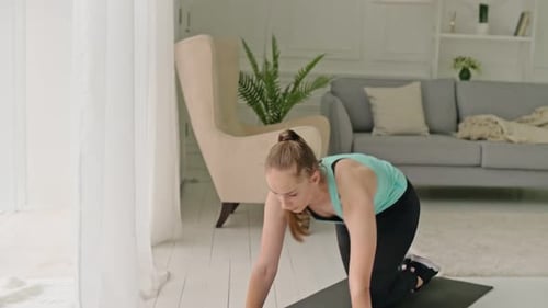 Woman Doing Leg Lifts on Yoga Mat Indoors