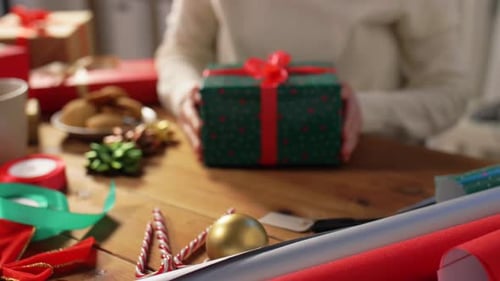 Woman Presents Christmas Gift with Festive Wrapping