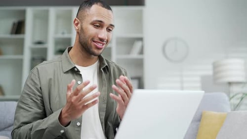 Man Talking on Laptop Video Call at Home
