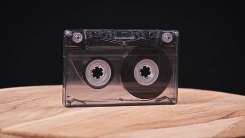 Rotating Cassette Tape on a Wooden Surface