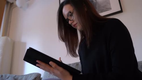 Young Woman Using Tablet on Couch Indoors