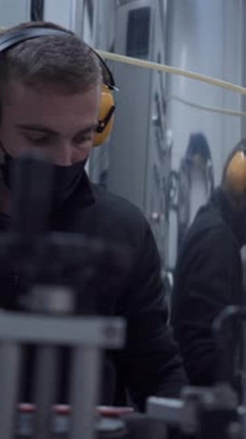 Young Adult Working with Industrial Machinery in Factory