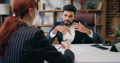 Woman and man business partners managers discussing working issues communicate in office.