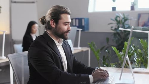 Man Typing at Computer in Bright Office