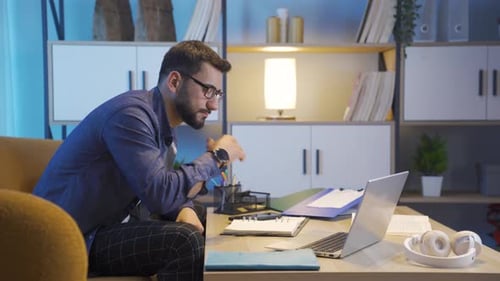 Man Working on Laptop at Home at Night