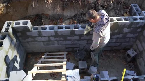 A Real Builder or Mason Building a Basement Wall