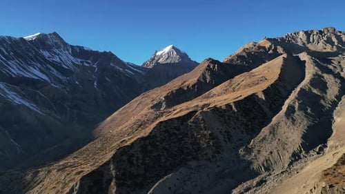 Mountain scenery in nepal highlands with snowy peaks and ridgeline, aerial flying