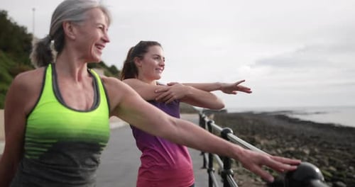 Senior woman warming up before a run with daughter