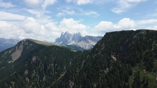 Panorama of a beautiful mountain landscape with green meadows and forests and steep mountains in the