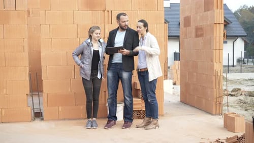 People Looking at Tablet at Construction Site