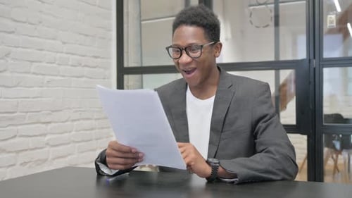 Man Celebrates Good News at Office Desk